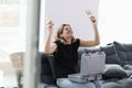 Happy smiling woman holding stacks of dollar bills and suitcase full of money on knees Royalty Free Stock Photo