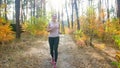 Happy smiling woman in leggings running in forest on sunny day