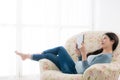 Happy smiling woman lying down on sofa chair Royalty Free Stock Photo