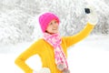 Happy smiling woman makes self portrait on smartphone in winter Royalty Free Stock Photo