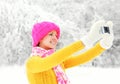 Happy smiling woman makes self-portrait on smartphone in winter Royalty Free Stock Photo