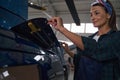 Beautiful Caucasian female engineer in uniform inspecting details of helicopter Royalty Free Stock Photo