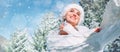 Happy smiling woman portrait in knitwear and fur hat enjoys with a hot cup of tea on sunny winter day during snowy forest walk. Royalty Free Stock Photo