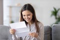 Happy smiling woman reading paper letter, receive good news at home