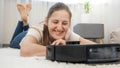 Happy smiling woman rejoicing at her new robot vacuum cleaner doing housework and cleaning dust at home Royalty Free Stock Photo