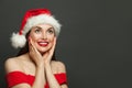 Happy smiling woman in Santa hat on black background. Christmas holiday and New Year party Royalty Free Stock Photo