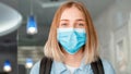 Happy smiling woman Schoolgirl in blue protective mask with backpack. Young woman student in medical mask. Portrait of blonde