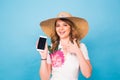 Happy smiling woman showing cell phone with black screen and gesturing thumb up, on a blue background Royalty Free Stock Photo