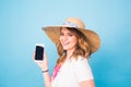 Happy smiling woman showing cell phone with black screen on a blue background Royalty Free Stock Photo