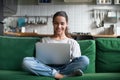 Happy smiling woman sitting on sofa and using laptop Royalty Free Stock Photo