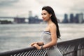 Happy smiling woman standing on ocean pier in New York City and looking to the side. Royalty Free Stock Photo