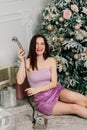 Happy smiling woman talking with retro phone near beautiful Christmas tree in winter holidays Royalty Free Stock Photo