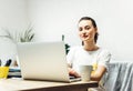 Happy smiling woman using laptop at home, looking at screen