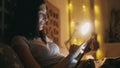 Happy smiling woman using tablet computer for sharing social media lying in bed at home at night Royalty Free Stock Photo