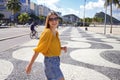 Happy smiling woman walking along Copacabana beach promenade and turns to the camera, Rio de Janeiro, Brazil Royalty Free Stock Photo