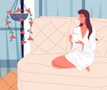 Happy smiling woman wearing bathrobe relaxing at sofa with a cup of drink at home, cheerful brunette