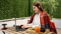 Happy smiling woman working on the terrace and drinking coffee while having a breakfast. Concept of freelancer, working from home Royalty Free Stock Photo