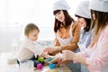 Happy smiling women baking together with little baby girl at home kitchen, Mothers Day, Family concept. Women are Royalty Free Stock Photo