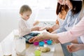 Happy smiling women baking together with little baby girl at home kitchen, Mothers Day, Family concept. Women are Royalty Free Stock Photo