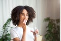 Happy smiling young african american woman taking pill or vitamin with cod liver oil omega-3 Royalty Free Stock Photo