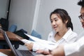 Happy smiling young Asian business woman working together with colleagues in the office. Business teamwork cooperation partnership Royalty Free Stock Photo