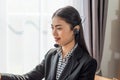 Happy smiling young Asian female customer support phone operator at her home, Call Center Service, Telephone operator Royalty Free Stock Photo