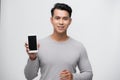 Happy smiling young Asian man showing mobile phone on white Royalty Free Stock Photo