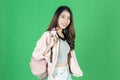 Happy smiling young Asian tourist girl with bag ready to travel over green isolated background Royalty Free Stock Photo