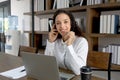 Happy smiling young beautiful curly hair woman with headset working on laptop computer, female officer staff having conference Royalty Free Stock Photo