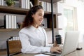 Happy smiling young beautiful curly hair woman with headset working on laptop computer, female officer staff having conference Royalty Free Stock Photo