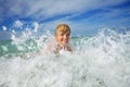 Boy play in ocean wave with water splashes during vacations Royalty Free Stock Photo