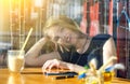 Happy smiling young blond woman drinking a latte in a cafe for a glass, sunglasses and phone in foreground. morning sun Royalty Free Stock Photo