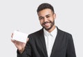 Happy smiling young businessman showing blank card, isolated over gray background. Handsome man with white card Royalty Free Stock Photo
