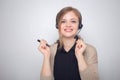 Happy smiling young caucasian woman with headset phone in a call center or office Royalty Free Stock Photo