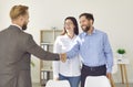 Happy, smiling young couple exchanging handshakes with professional real estate agent Royalty Free Stock Photo