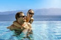 Happy smiling young couple having fun together in infinity swimming pool. romantic summer vacation Royalty Free Stock Photo