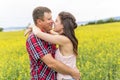 Happy smiling young couple over yellow green meadow Royalty Free Stock Photo