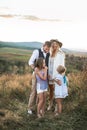 Happy smiling young family, father, mother and two little daughters having fun outdoors, standing together in a wild Royalty Free Stock Photo