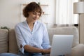 Happy smiling young female communicating with friends using laptop