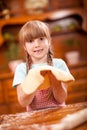 Happy smiling young girl chef in kitchen making dough Royalty Free Stock Photo