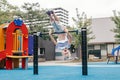 Happy smiling young girl exercising on children pull-ups bar outdoors at playground park. Child hanging on high bar upside down. Royalty Free Stock Photo