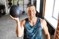 Happy smiling young man with medicine ball in gym Royalty Free Stock Photo