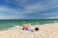 Happy smiling young man sunbathing on beach towel Royalty Free Stock Photo