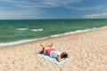 Happy smiling young man sunbathing on beach towel Royalty Free Stock Photo