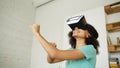 Happy smiling young mixed race girl getting experience using VR headset glasses of virtual reality and dancing at home Royalty Free Stock Photo