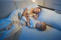 Happy smiling young mother lying in bed with her 9 months old baby son at night Royalty Free Stock Photo