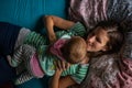 Happy smiling young mother lying on bed playing with her baby Royalty Free Stock Photo