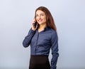 Happy smiling young positive woman with long curly hairstyle in business office clothing talking on mobile phone and looking up on Royalty Free Stock Photo