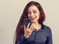 Happy smiling young positive woman with long curly hairstyle in business office clothing talking on mobile phone and looking up on Royalty Free Stock Photo