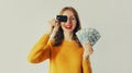 Happy smiling young 20s caucasian woman holding plastic credit bank card and cash money in dollar bills Royalty Free Stock Photo